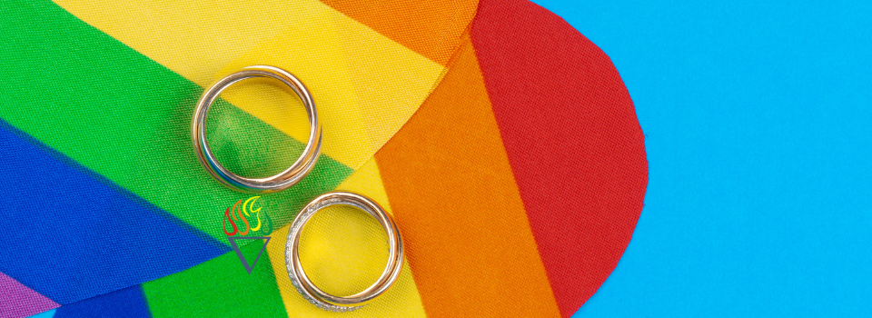 Two Wedding Rings Against Rainbow-Colored Hearts